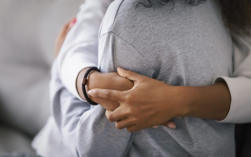 Loving african american foster care parent single mother sister embrace teen daughter giving support and protection, black mom hug teenage girl, family kindness concept, close up view, focus on hands