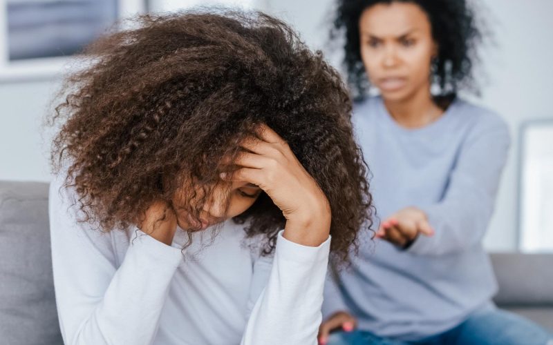 Upset african american teenage girl feeling sad turned back to angry strict black mother scolding lecturing difficult kid for bad behavior, mad mom arguing shouting at stubborn child teen daughter