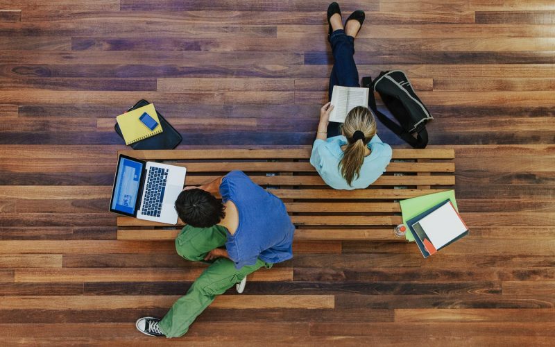 Top view of male and female university students studying