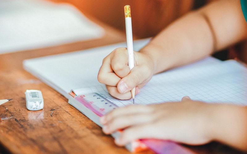 Children's hands are doing their homework.