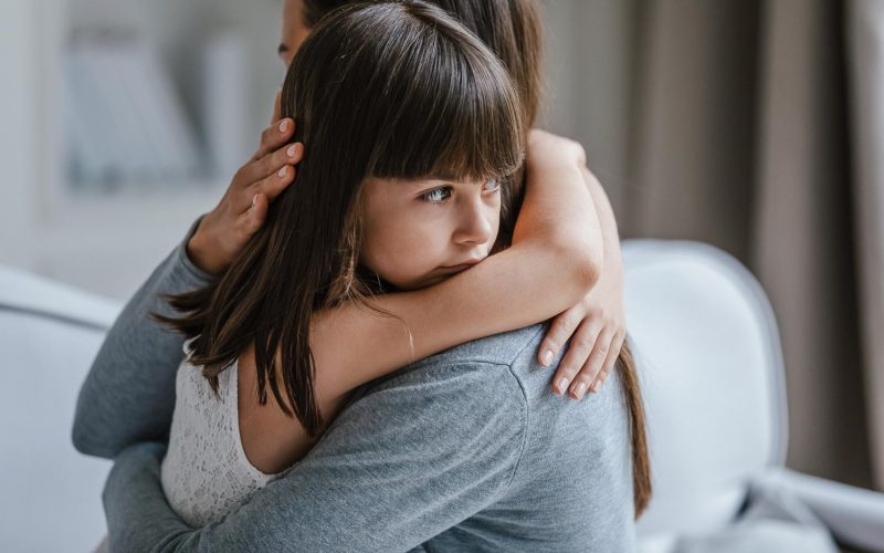 Close up view of upset little daughter cuddling mother, child receiving protection and support from mommy, adopted kid girl and new parent, sole custody, offspring and motherhood connection concept