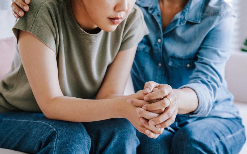 Middle aged asia people old mom holding hands trust comfort help young woman talk crying stress relief at home. Mum as friend love care hold hand adult child feel pain sad worry of life crisis issues.