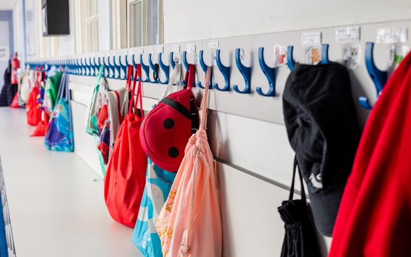 Coats and bags hung up on pegs in a primary school in the North East of England.