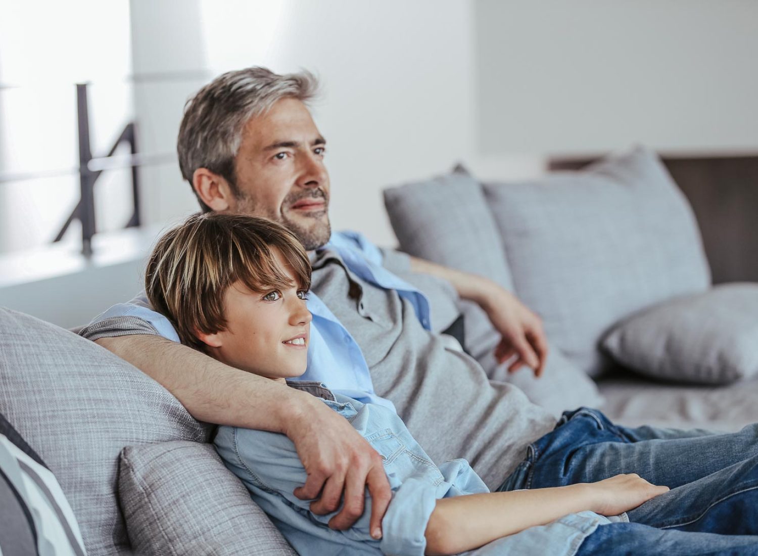 Father and son relaxing in sofa a thome