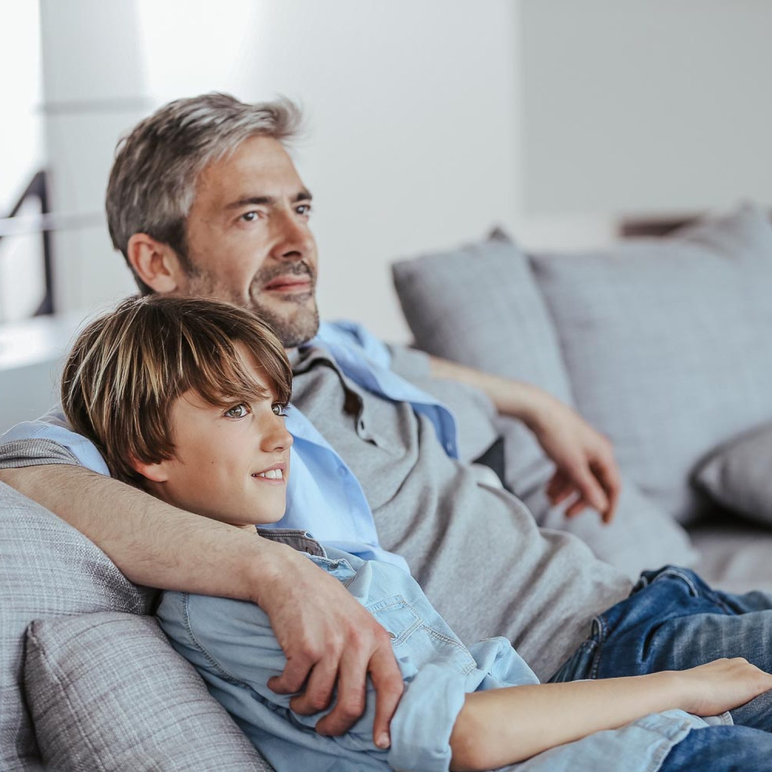 Father and son relaxing in sofa a thome