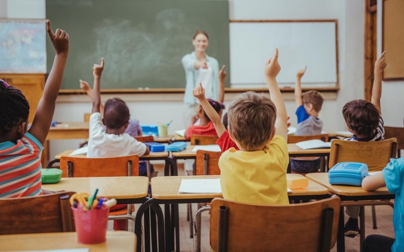 Pupils raising their hands during class at the elementary school