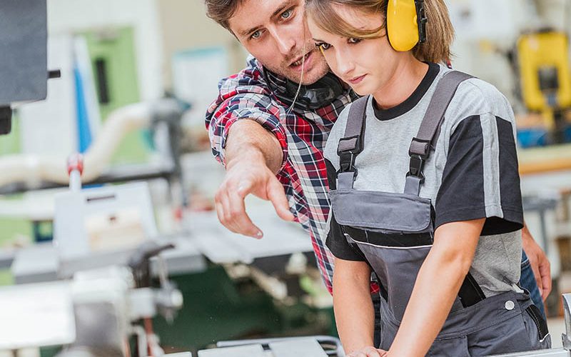 young apprentice with professional carpenter