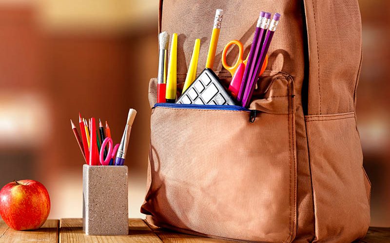 old wooden school table and school supplies on September day